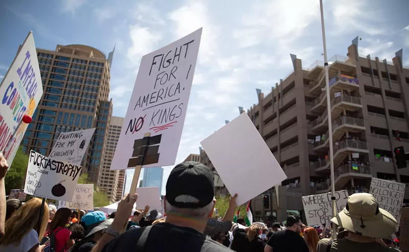 Image: protesters hold signs in the air