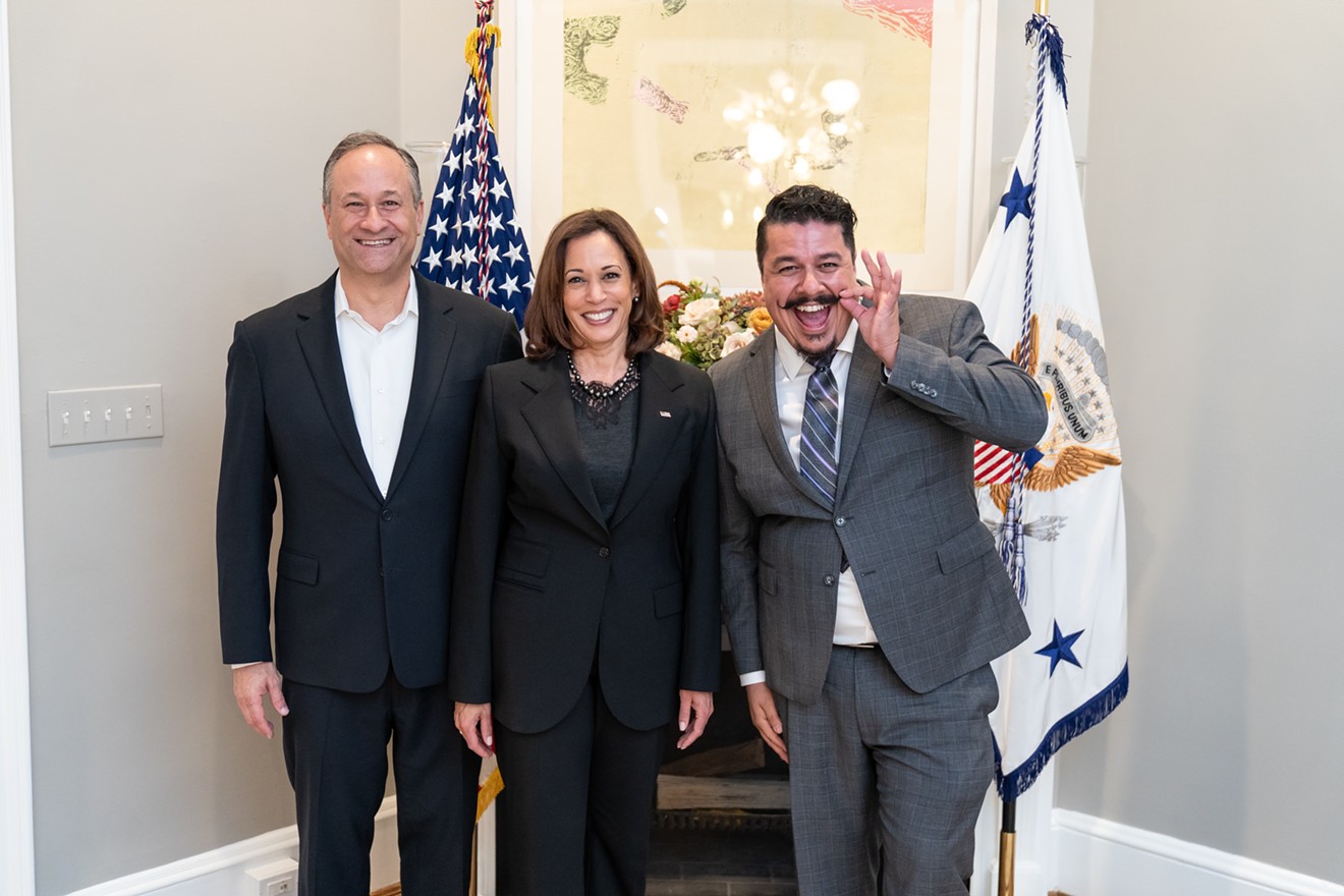 José "ET" Rivera pulls on his signature mustache during a photo op with Vice President Kamala Harris and her husband, Douglas Emhoff.