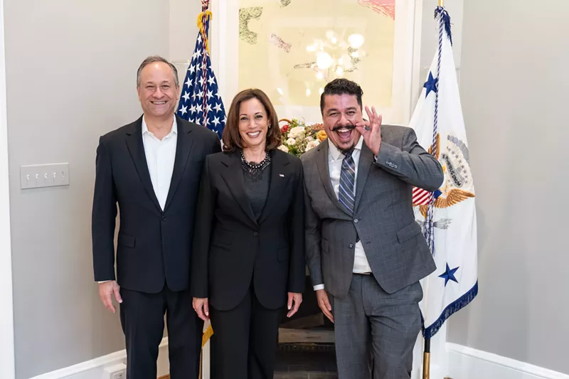 Image: José "ET" Rivera pulls on his signature mustache during a photo op with Vice President Kamala Harris and her husband, Douglas Emhoff.
