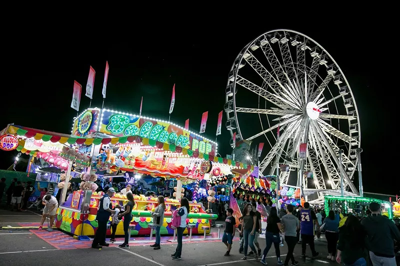 Image: A carnival with rides and food at nighttime.