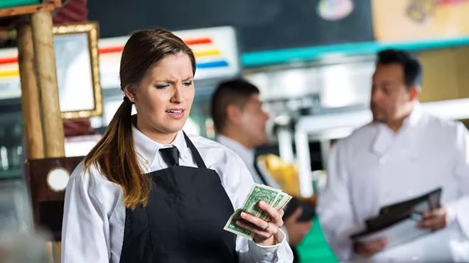 a restaurant server looks disappointedly at a meager tip