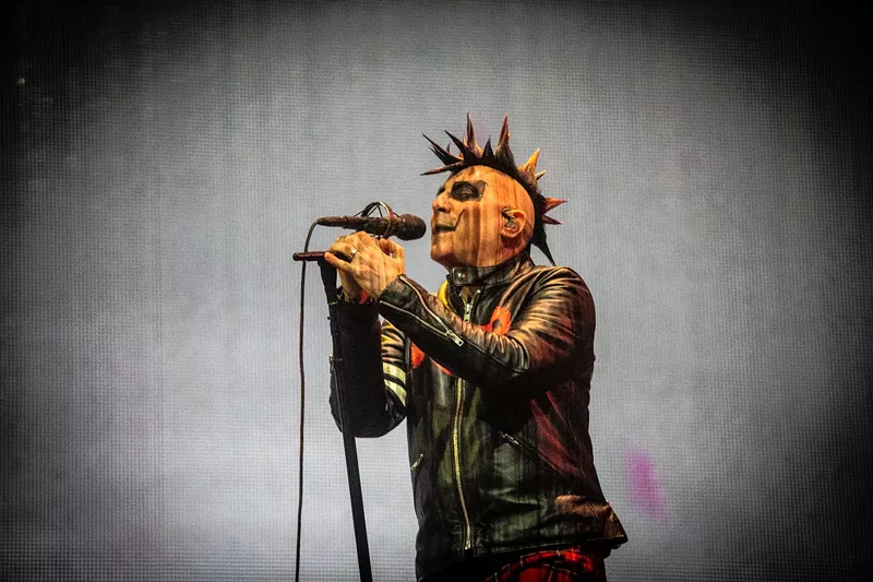 Image: A man in makeup singing.