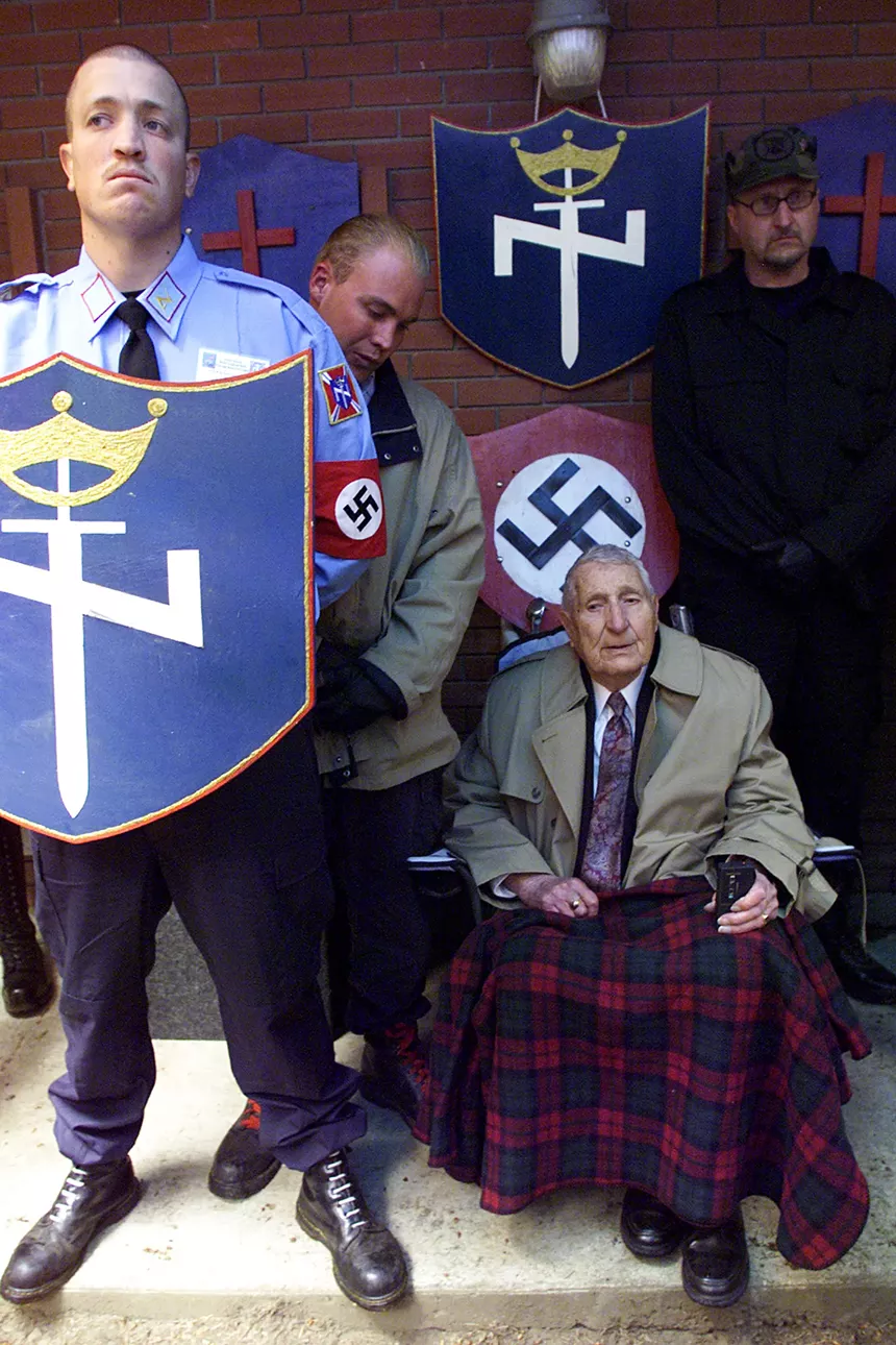 Richard Butler, founder and leader of the Aryan Nations, is surrounded by bodyguards at the Aryan Nations World Congress June 21, 2003 at Farragut State Park, Idaho. - JEROME A. POLLOS/GETTY IMAGES