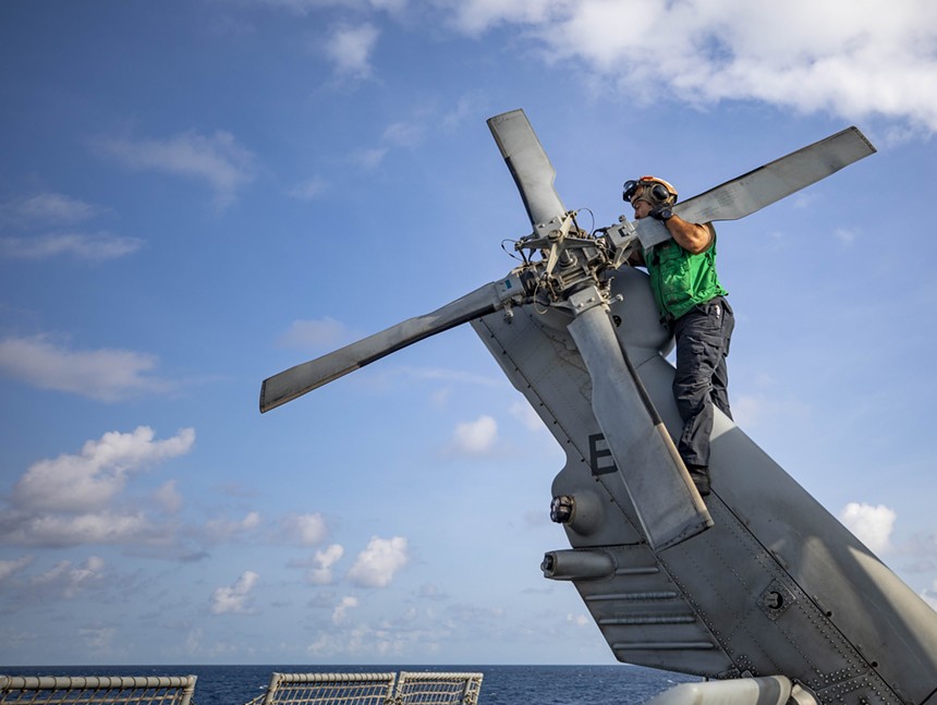 A sailor conducts maintenance on the tail rotor of an MH-60S Helicopter assigned to Helicopter Sea Combat Squadron (HSC) 28. - AUSTIN COLLINS (U.S. NAVY)