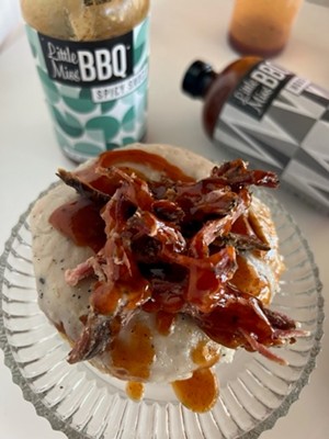 A brown butter doughnut topped with Little Miss BBQ pulled pork and sauce at Chin Up Donuts. - ALEX MCENTIRE
