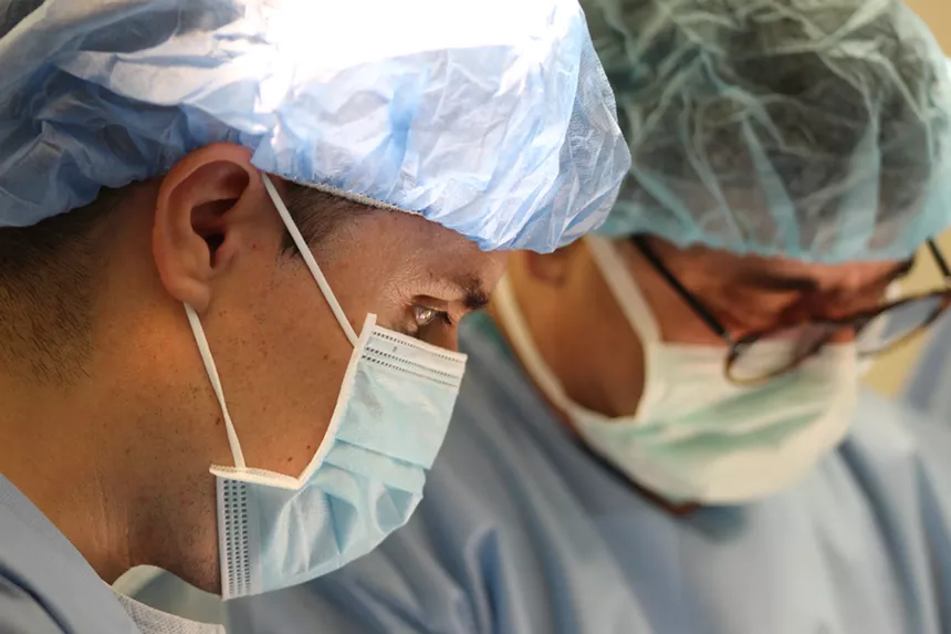 Despite a language barrier, Dr. Adan Larez (left), a physician from the Mexican border town of Sonoyta, works on an operation with Mesa-based Dr. Joseph Abdo for free at Hospital General de Puerto Peñasco on Saturday. - ELIAS WEISS