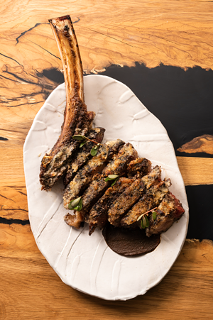 The sensational Wagyu Tomahawk ribeye at Tía Carmen is served with marrow butter and black bean mole tepary. - AUNT CARMEN