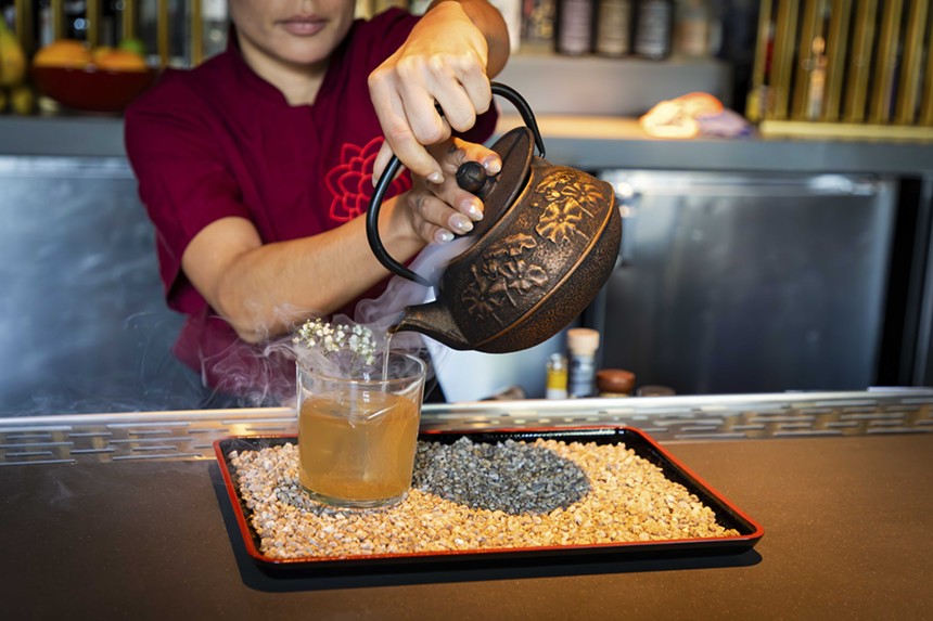 Bartender pours cocktail from a teapot at Kembara.