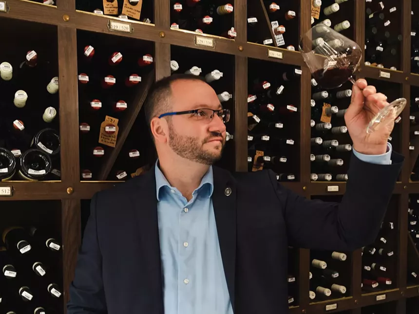 Mark Guilladeu samples a wine inside the Wrigley Mansion's wine cellar.