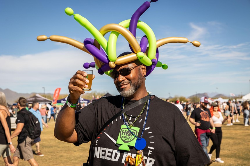 Man in a balloon hat with beer.