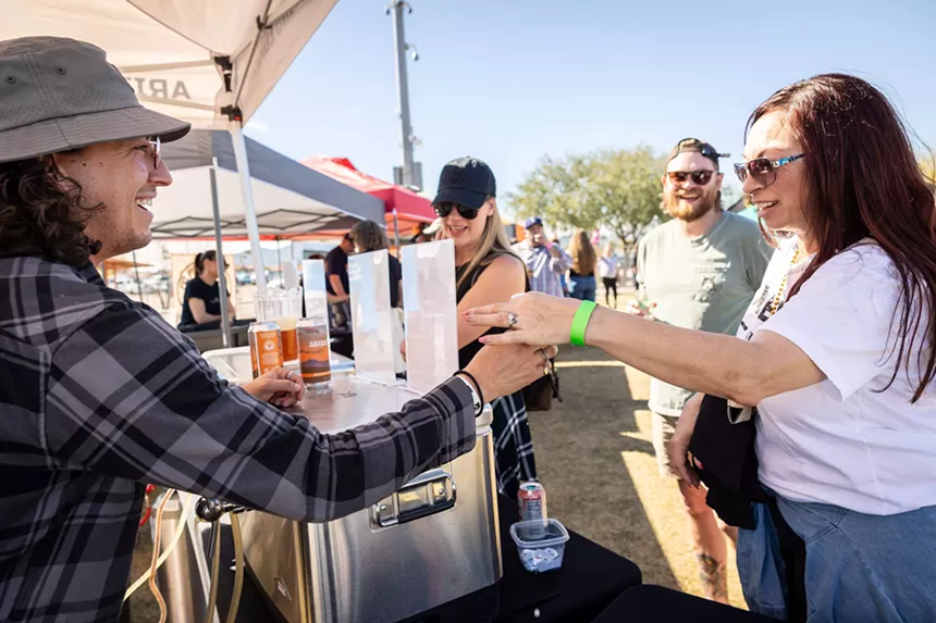 Man hands beer to woman.