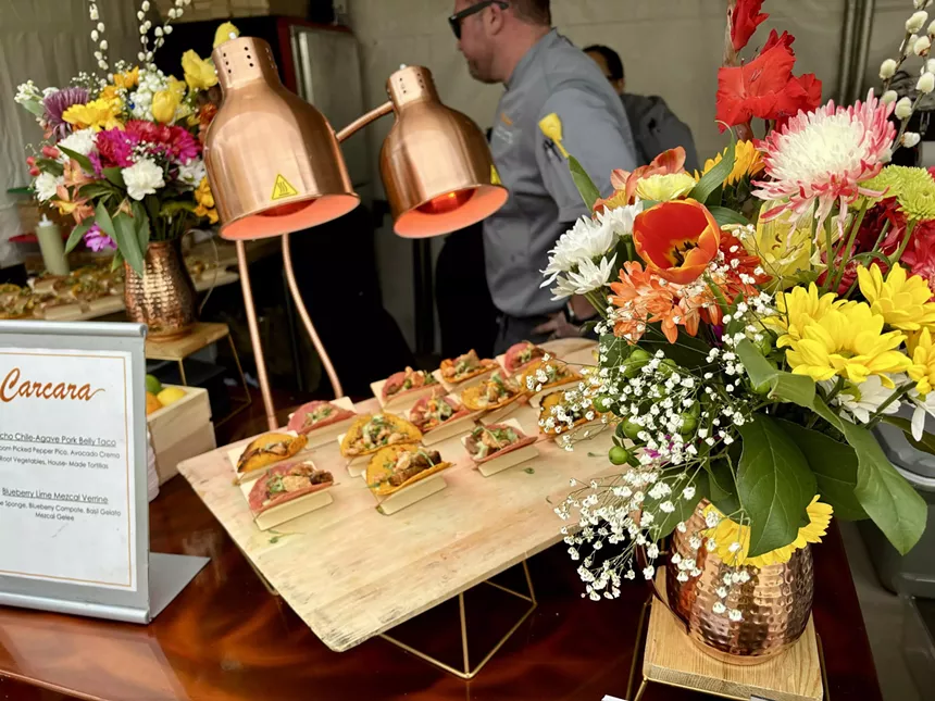 Flowers and tacos on a table.