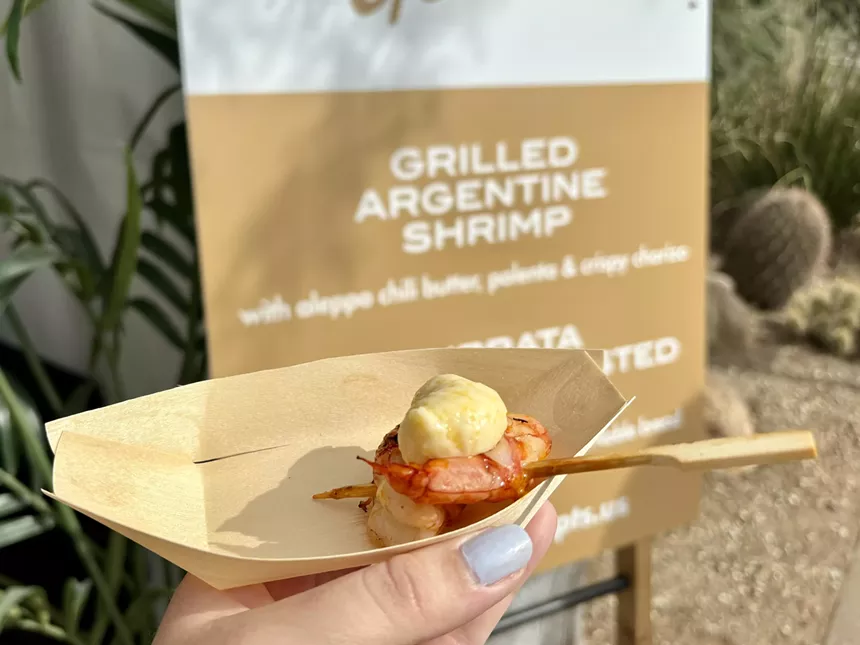 Shimp in a bamboo dish in front of menu sign.