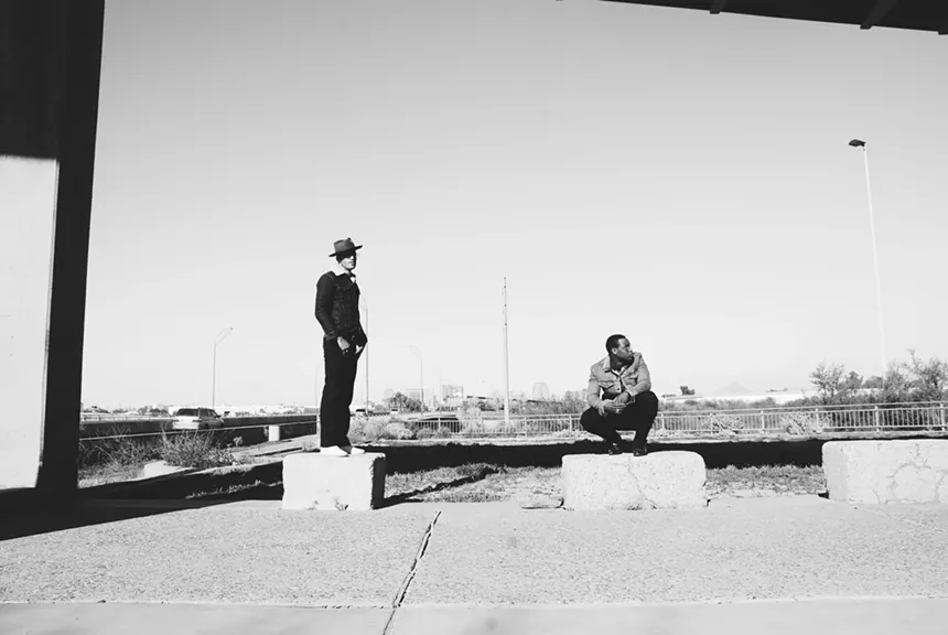 Two men standing on concrete blocks outdoors.