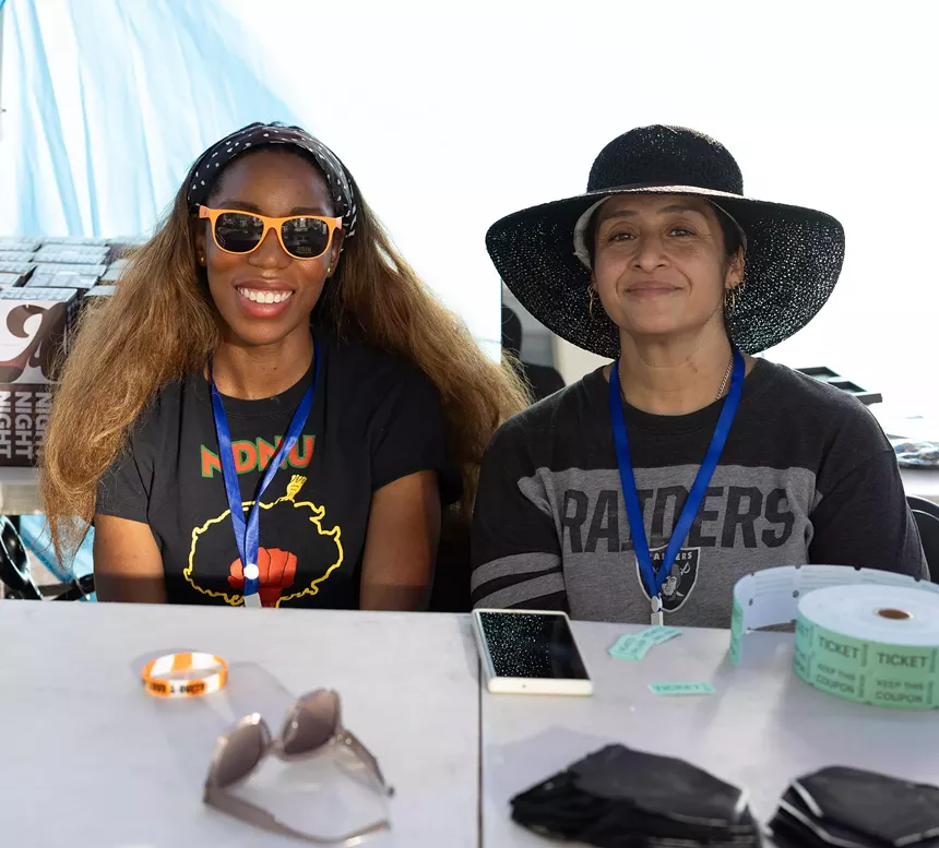 Two women sitting behind a table.