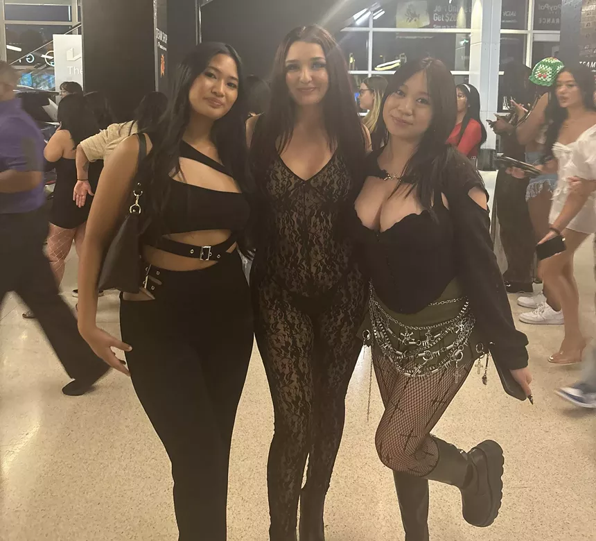 Three women standing together at a concert.