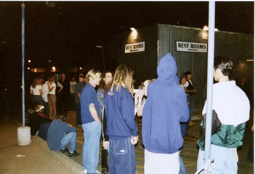 A group of '90s club kids lining up outside a nightclub.