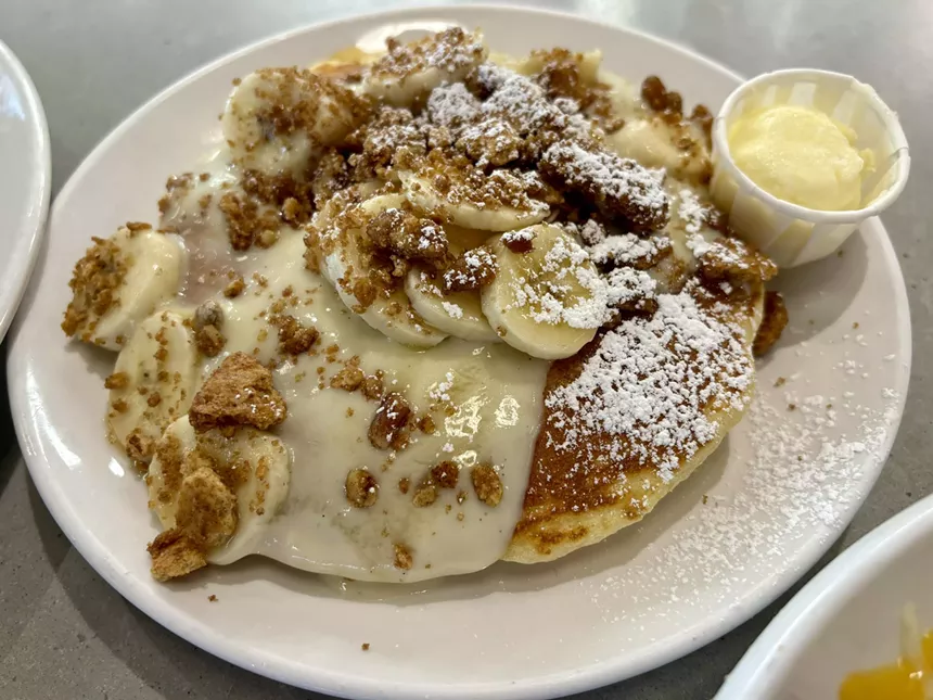 Plate of pancakes with bananas.