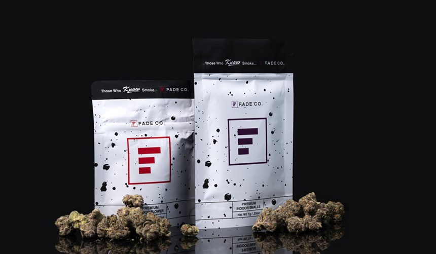 Bags of Fade Co. cannabis surrounded by buds of marijuana.