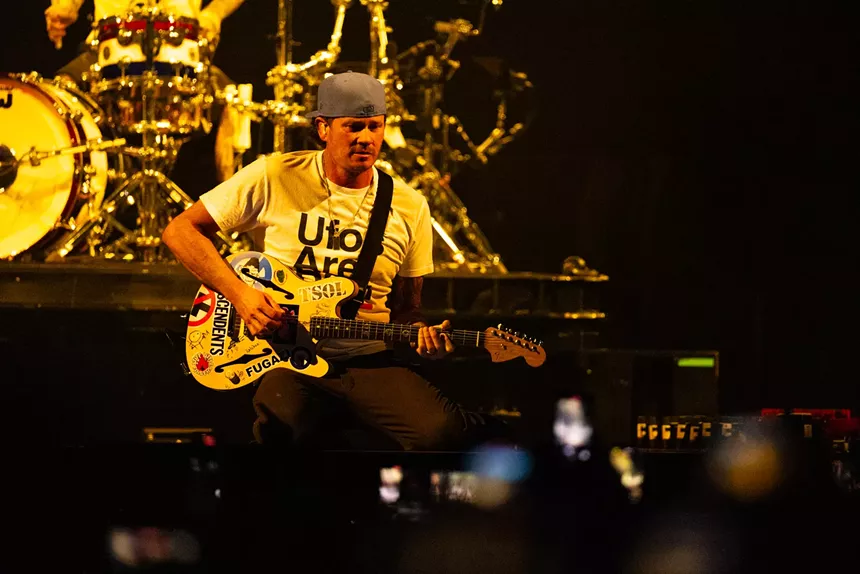 A man playing guitar onstage.