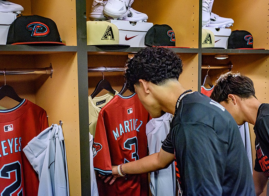 High school boys look at baseball jerseys in a locker