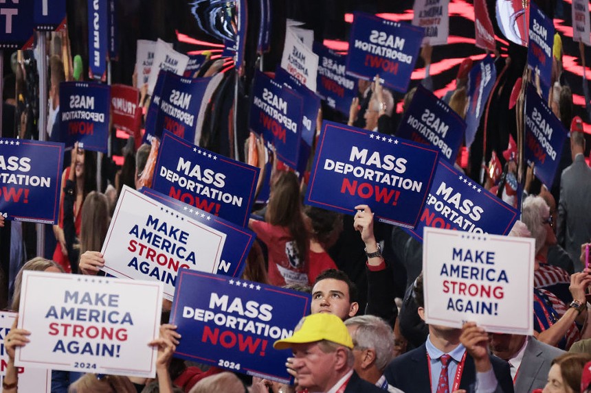 signs that read "Mass Deportation Now" and "Make America Strong Again"