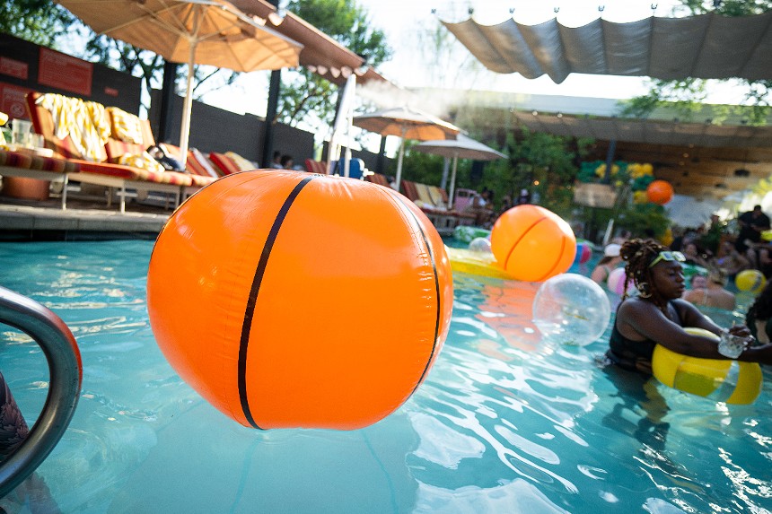 a basketball-colored beach ball in a pool