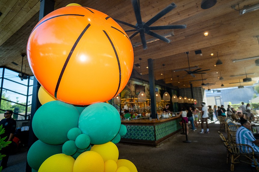 A basketball-colored beach ball on top of a tower of balloons
