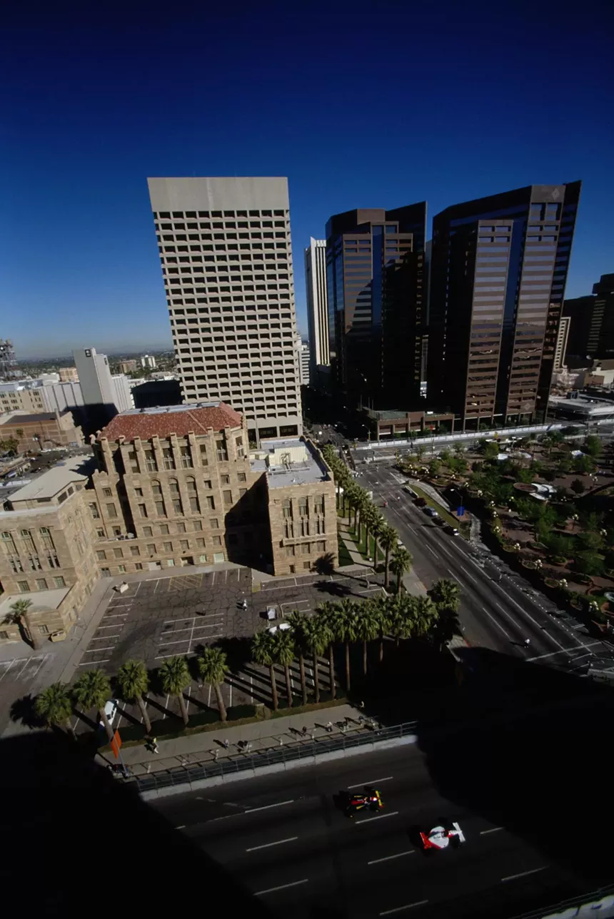 two formula 1 cars zoom by the old courthouse in phoenix in 1991