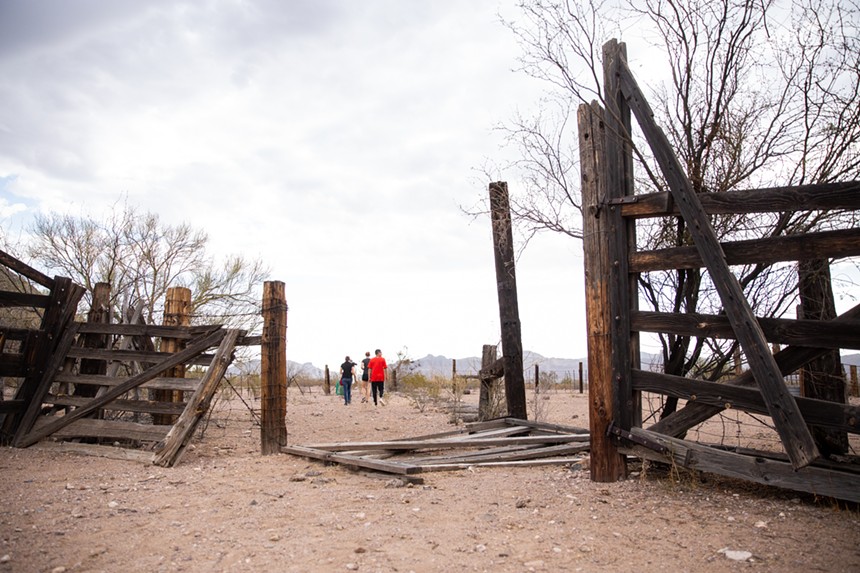 People walk through an abandoned corral