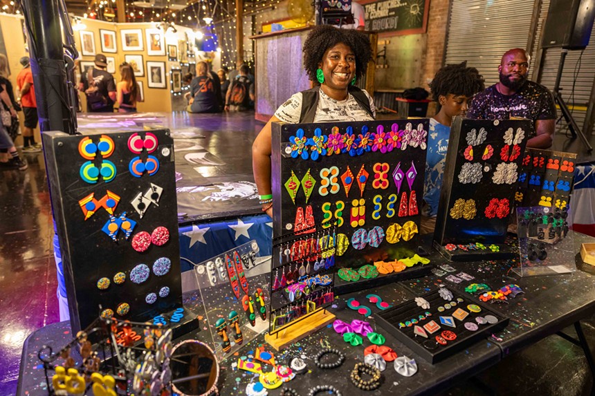 A woman behind a colorful jewelry display.