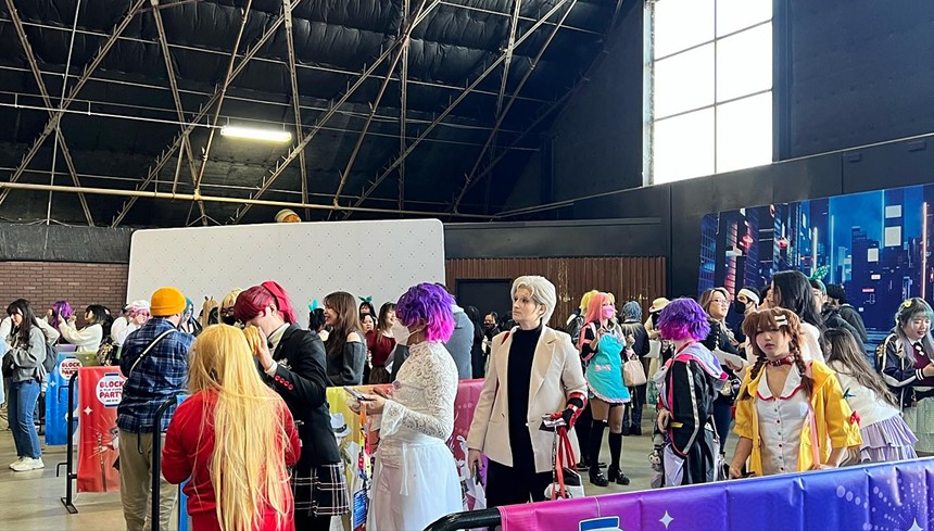 Anime fans in costume waiting in line.