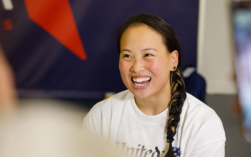 An Asian woman smiling.