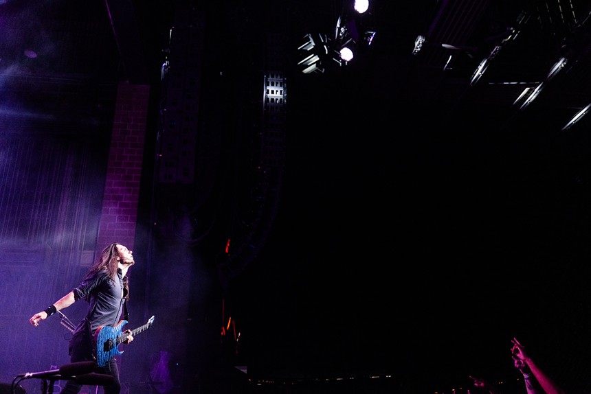 A man plays guitar onstage.