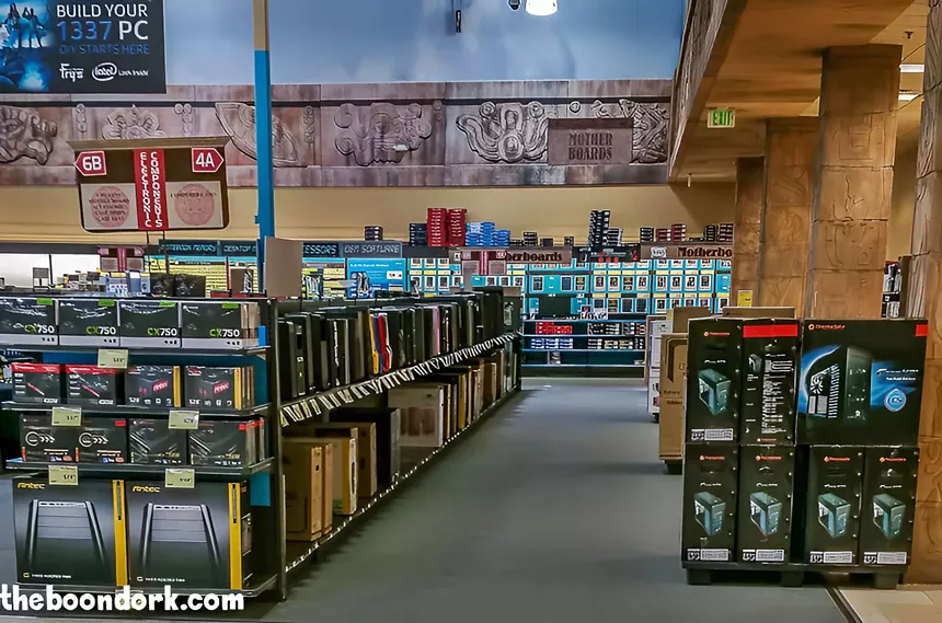 Rows of shelves stocked with computers in an electronics store.