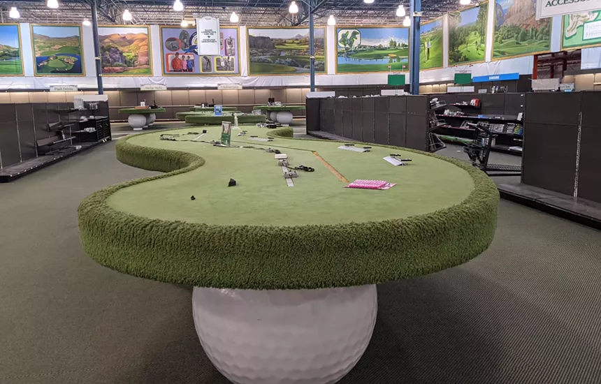 Empty tables and shelves inside an electronics store.