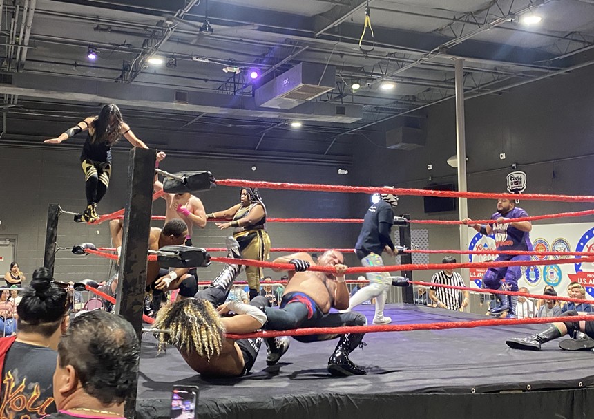 Multiple professional wrestlers battle in a ring.