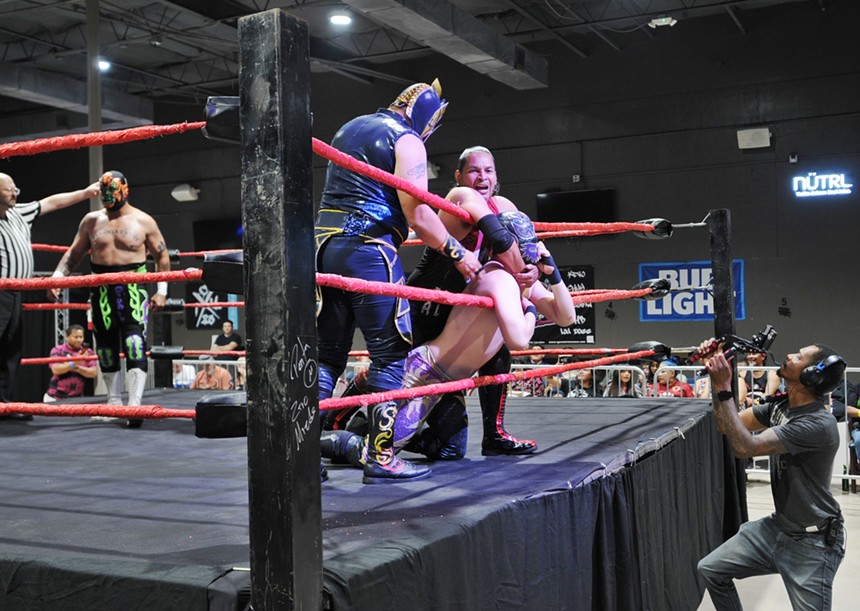 Multiple professional wrestlers battle in a ring.