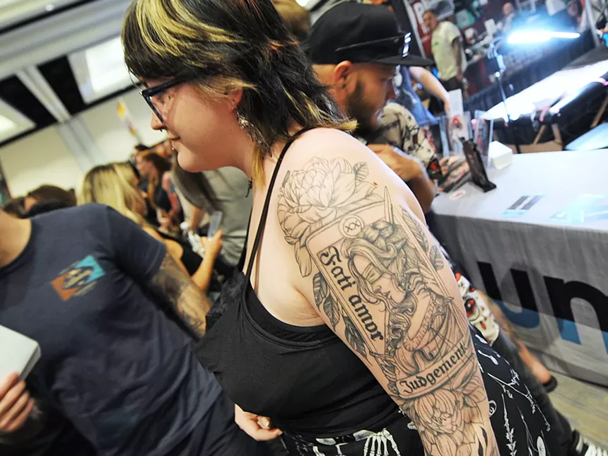 A woman shows off her arm tattoo.