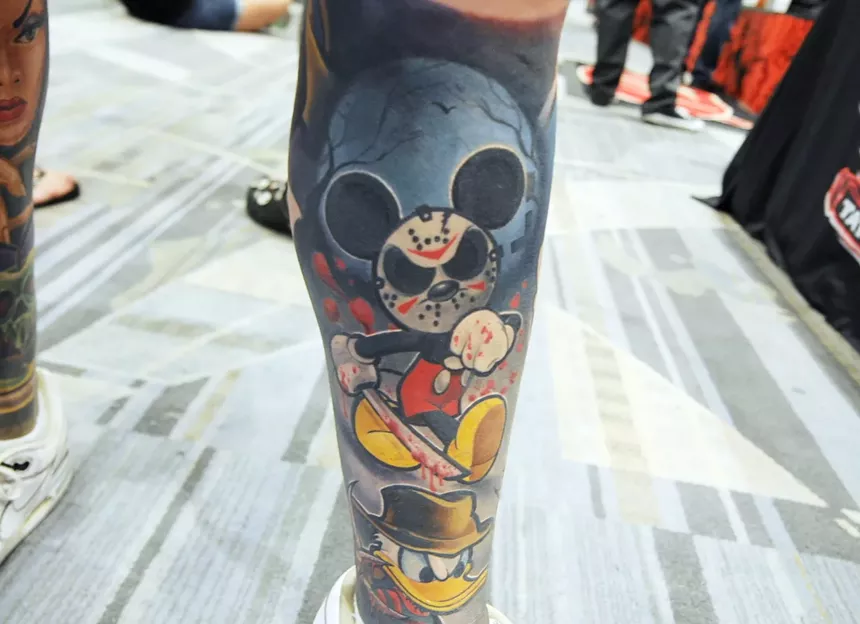 A leg tattoo with an evil Mickey Mouse.