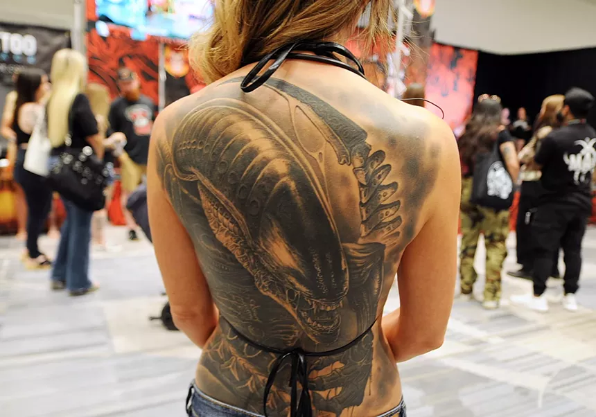 A backpiece tattoo with an alien.