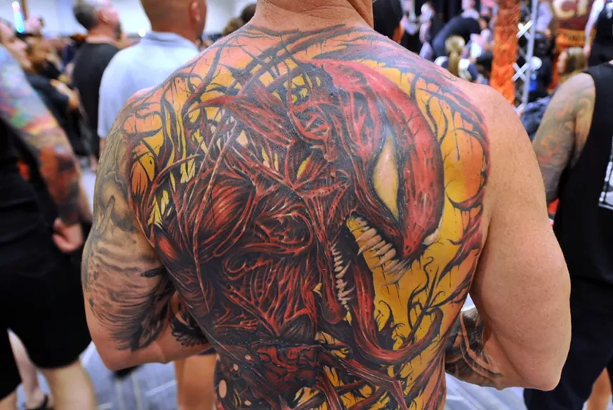 A large backpiece tattoo featuring a comic book character.