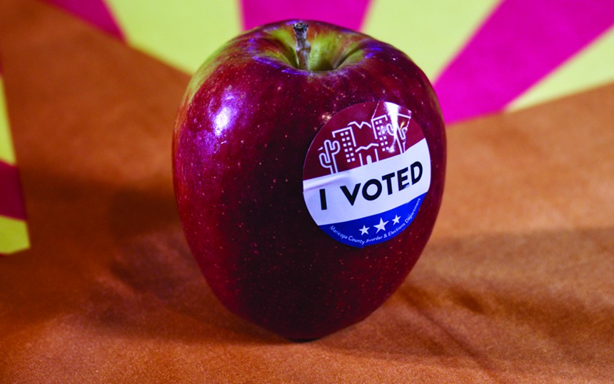 an apple with an "I voted" sticker on it