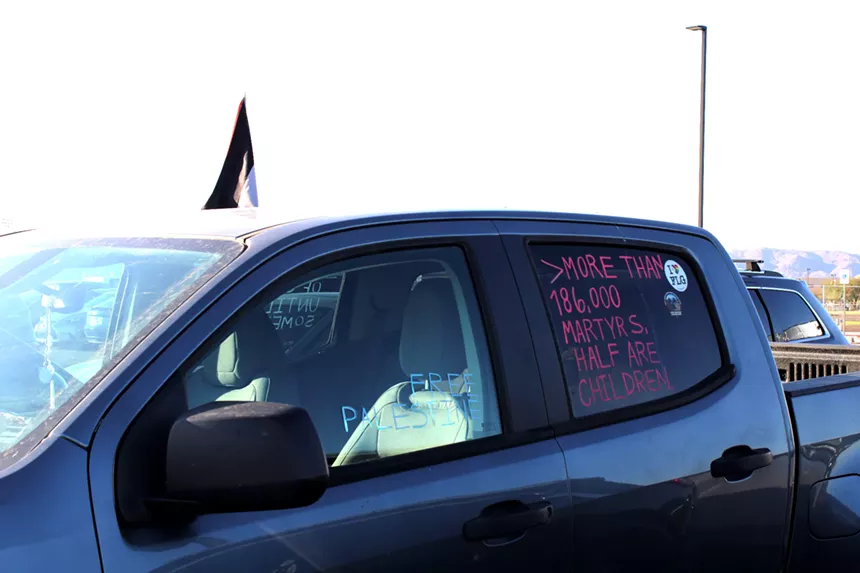 a truck with "Free Palestine" and "More than 186,000 martyrs, half are children" written on the windows