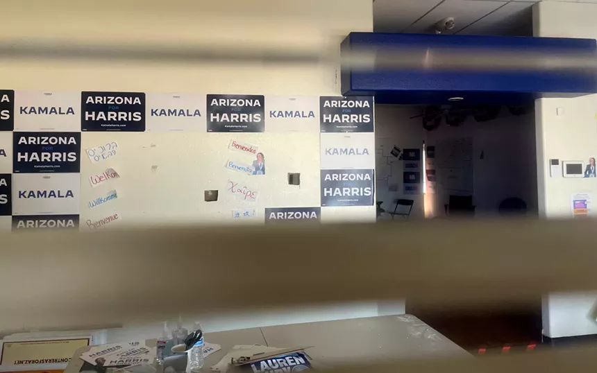 send through a window blind, a room wtih Kamala Harris signs on the walls