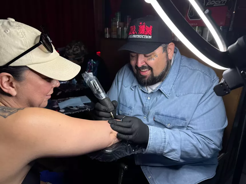a man giving a tattoo