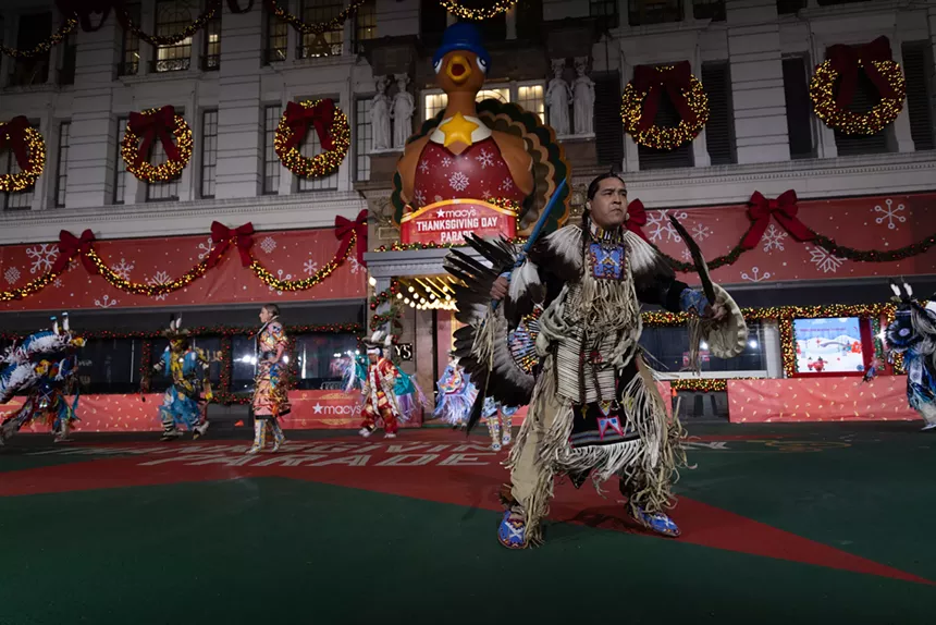 A Native American man performs a dance.