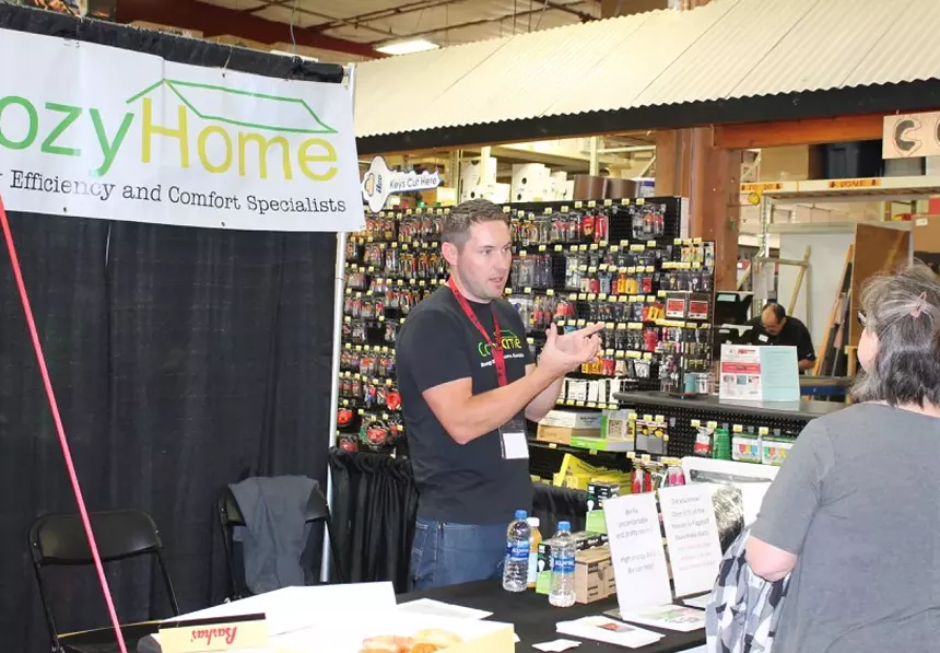 a man at a booth talks to customers