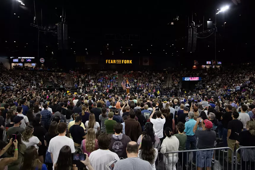 a full stadium with a 'fear the fork' sign in the background