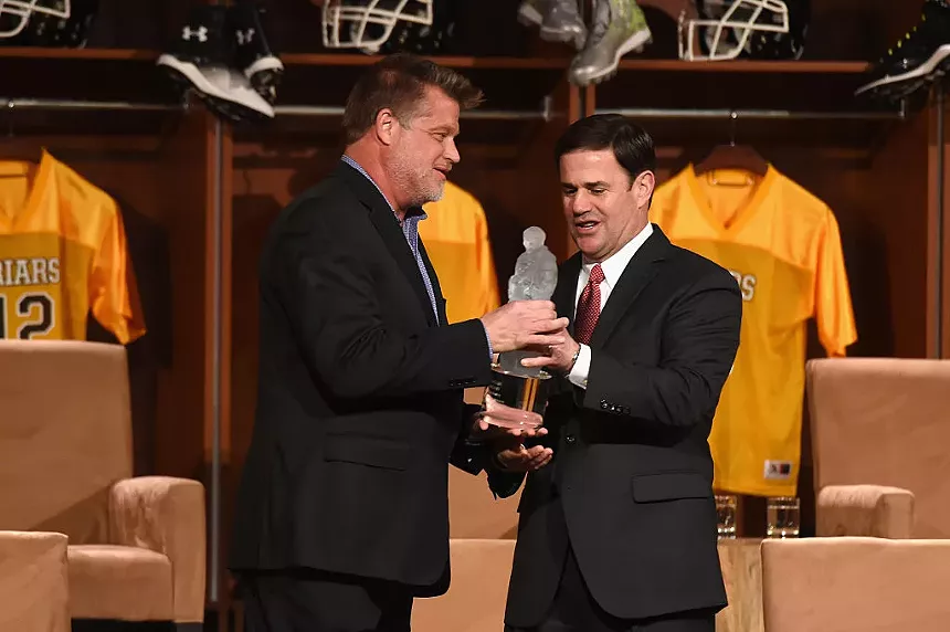 one man hands an award to another